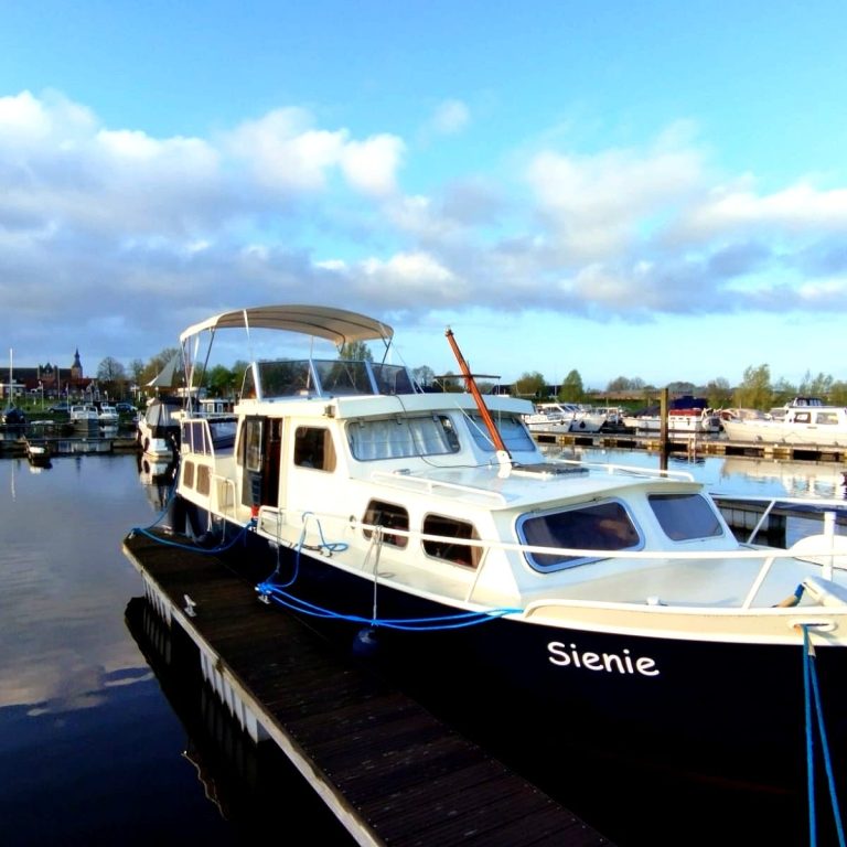 Fotograf Angabe: Aaron Zimmermann Ein Boot namens "Sienie" liegt an einem Yachthafen bei wolkigem Himmel.